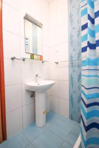 a white bathroom with a sink and a shower at Apartments Mira in Cavtat