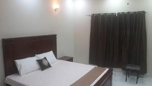 ein Schlafzimmer mit einem Bett und einem schwarzen Vorhang in der Unterkunft 5-Bedroom Vacation Home in Lahore