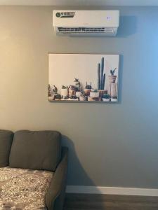 a living room with a couch and a picture of cactus at ATX Tiny House in Austin