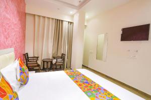 a hotel room with a bed and a flat screen tv at FabHotel Uday Villa in Kānpur