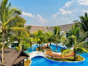 an aerial view of a resort pool with palm trees at Manyo Hotel and Resort in Luang Prabang