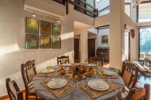 a dining room with a table with food on it at The Beach House by StayVista with Modern interiors, nearby beach, pool, lawn in Alibaug