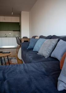 - un salon avec un canapé bleu et une table dans l'établissement Skyline Apartment 1, à Peje