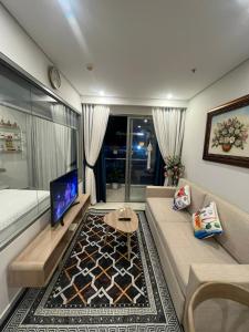 een woonkamer met een bank en een tv bij Premium 2pn The Sóng 5 Sao Homestay Khánh Vân in Vung Tau
