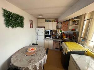 una pequeña cocina con mesa y nevera en Departamento Céntrico, cómodo y acogedor, en Puno