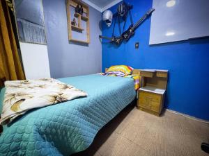 1 dormitorio con cama y pared azul en Departamento Céntrico, cómodo y acogedor, en Puno