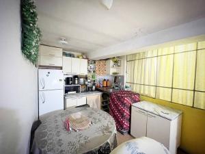 una pequeña cocina con mesa y nevera blanca en Departamento Céntrico, cómodo y acogedor, en Puno