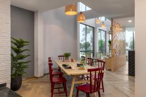 une salle à manger avec une table en bois et des chaises rouges dans l'établissement Ginger Durgapur, à Durgapur
