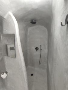 a bathroom with a shower with a toilet and a sink at Central Santorini Serenity Rooms in Fira