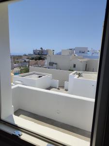 a view from a window of a white building at Central Santorini Serenity Rooms in Fira