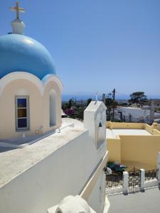 a church with a blue dome on top of a building at Central Santorini Serenity Rooms in Fira