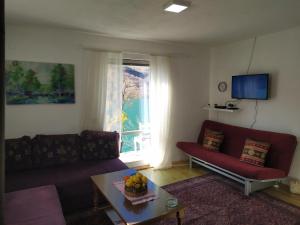 a living room with a couch and a table and a window at Mostar House in Mostar