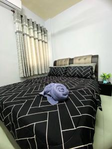 uma toalha roxa deitada numa cama num quarto em Izdisa Muslim Homestay For Muslim Groundfloor Pool view em Porto Dickson