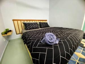 a bed with a purple blanket on top of it at Izdisa Muslim Homestay Teluk Kemang Groundfloor unit with Pool view in Port Dickson