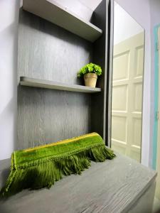 Habitación con cama con alfombra verde y espejo. en Izdisa Muslim Homestay For Muslim Groundfloor Pool view, en Port Dickson