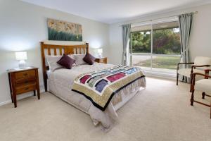 sypialnia z dużym łóżkiem i oknem w obiekcie Brookfield Guest House w mieście Myrrhee