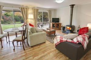 a living room with a couch and a fireplace at Brookfield Guest House in Myrrhee