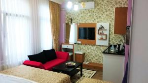 イスタンブールにあるGrafen Houseの赤いソファとテレビが備わるホテルルームです。