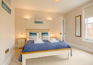 a bedroom with a bed with two towels on it at Salisbury House in Southwold