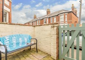 a bench sitting next to a brick wall with a fence at Salisbury House in Southwold