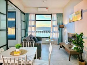 sala de estar con sofá y mesa en #10 Jesselton Quay City Pads Seaview by Zeluxo en Kota Kinabalu