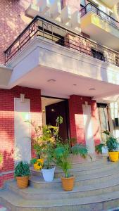 un bâtiment avec des plantes en pot sur les escaliers dans l'établissement HOTEL AP INTERNATIONAL, à Noida