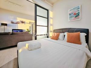 Cama blanca grande en habitación con sofá en #10 Jesselton Quay City Pads Seaview by Zeluxo en Kota Kinabalu