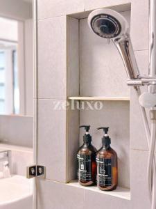 Baño con 2 botellas de jabón en una estantería en #10 Jesselton Quay City Pads Seaview by Zeluxo en Kota Kinabalu