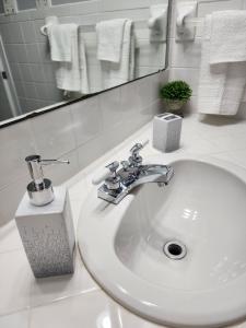 La salle de bains est pourvue d'un lavabo, d'un robinet et d'un miroir. dans l'établissement Willow Way: Cozy Retreat, à Fort Smith