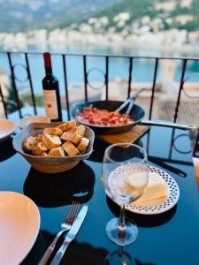 een tafel met twee kommen eten en een fles wijn bij Hartmut Friedrich Apartment Port de Soller in Port de Soller