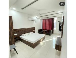 um quarto com uma cama e uma cortina vermelha em Town house cafe and hotel, Kurukshetra em Kurukshetra