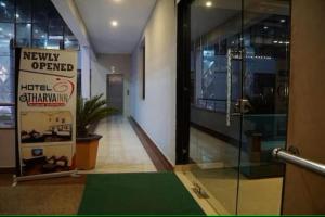 un couloir avec une porte en verre et un panneau dans un bâtiment dans l'établissement Hotel Suncity & Restaurant, à Hisār