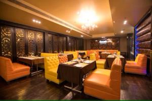 Hotel Suncity & Restaurant في Hisār: مطعم فيه طاولات وكراسي في الغرفة