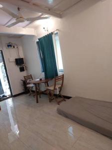 Cette chambre comprend un lit, une table et des chaises. dans l'établissement 1bhk flat Bandra, à Mumbai