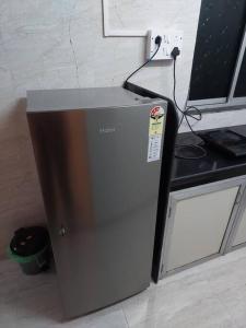 a small refrigerator in a kitchen next to a counter at 1bhk flat Bandra in Mumbai