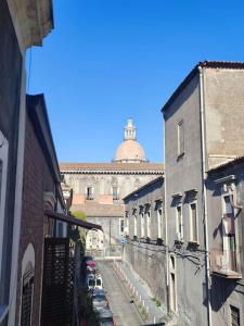 una calle de la ciudad con edificios y un edificio con una cúpula en BiBiHome Catania appartamento in centro storico, en Catania