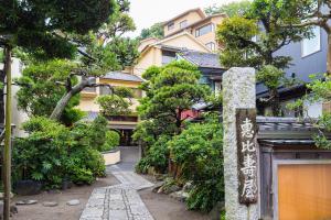 una passerella di fronte a un edificio alberato di 湘南江の島　御料理旅館　恵比寿屋 a Fujisawa