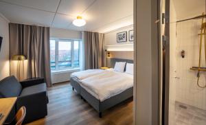 a hotel room with a bed and a couch at Go Hotel Herlev in Herlev