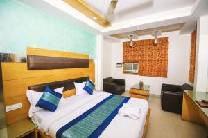 Habitación de hotel con cama y escritorio en Hotel Lav-Kush en Nueva Delhi
