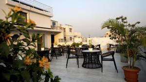 an outdoor patio with tables and chairs and plants at Xpressmall Hotel near Dhaka Airport in Dhaka