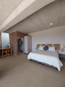 um quarto com uma cama grande e uma parede de tijolos em Chapman View em Cidade do Cabo