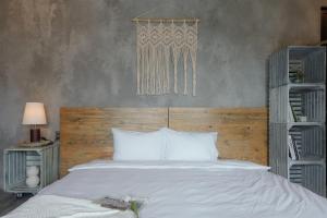 a bedroom with a white bed with a wooden headboard at Babylon Mini Resort in Vung Tau