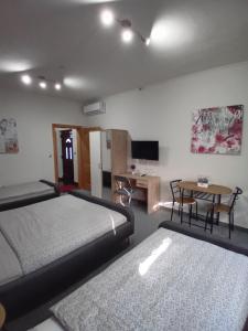 a bedroom with two beds and a desk and a television at Pansion San in Bihać