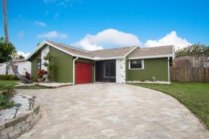 a green house with a red garage at Sunrise 3 bed @ sawgrass mills in Sunrise