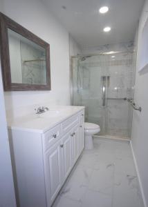 a white bathroom with a sink and a shower at Sunrise 3 bed @ sawgrass mills in Sunrise +5 photos
