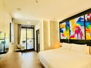 1 dormitorio con 1 cama y una gran pintura en la pared en 水秀一方Sun Moon Lakeside Boutique Hotel en Yuchi
