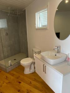 a bathroom with a sink and a toilet and a mirror at MakiSaki Beach House in Herolds Bay