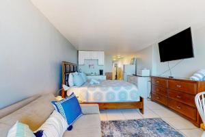 ein Schlafzimmer mit einem Bett, einem Sofa und einem TV in der Unterkunft Pirates Cove Unit G22 in Daytona Beach