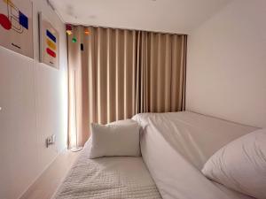 1 dormitorio con cama blanca y ventana en DOBOY House en Seúl