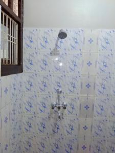 ein Bad mit einer Dusche mit blauen und weißen Fliesen in der Unterkunft Hotel zamarrud palace in Jaipur